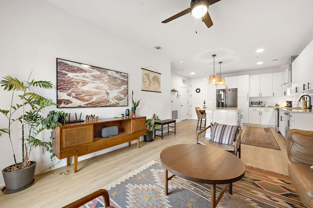 3101 Govalle Ave Unit 219, Austin, TX 78702 - living area featuring light wood-style floors, ceiling fan, and recessed lighting