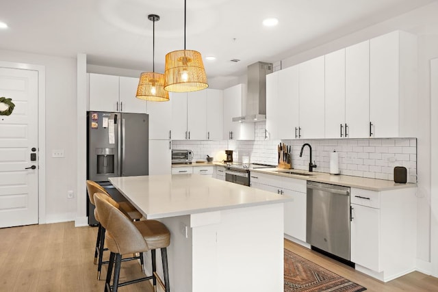 3101 Govalle Ave Unit 219, Austin, TX 78702 - kitchen with appliances with stainless steel finishes, wall chimney exhaust hood, a sink, light wood finished floors, and recessed lighting