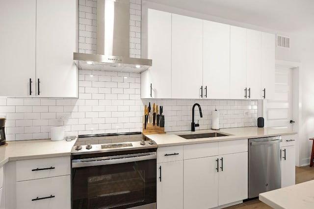 3101 Govalle Ave Unit 219, Austin, TX 78702 - kitchen featuring appliances with stainless steel finishes, wall chimney range hood, a sink, and decorative backsplash