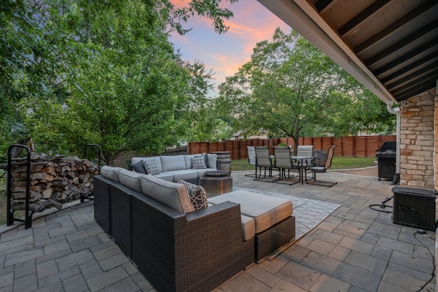 6610 Greensboro Dr, Austin, TX 78723 - patio terrace at dusk with an outdoor living space, outdoor dining area, a patio, and grilling area
