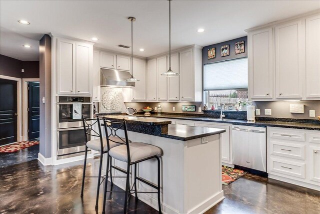 14722 Beal Dr, Corpus Christi, TX 78410 - kitchen featuring stainless steel appliances, concrete flooring, a kitchen bar, a center island, and white cabinets