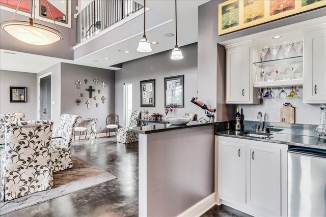 14722 Beal Dr, Corpus Christi, TX 78410 - kitchen featuring dishwasher, concrete floors, a towering ceiling, a sink, and white cabinets