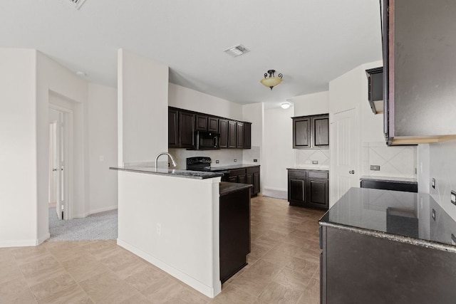 1105 Hawkeye Point Rd, Georgetown, TX 78626 - kitchen with black appliances, decorative backsplash, dark brown cabinetry, a peninsula, and dark stone countertops