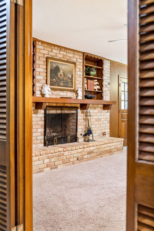 3503 Carla Dr, Austin, TX 78754 - living area with carpet flooring, a heating unit, and a brick fireplace