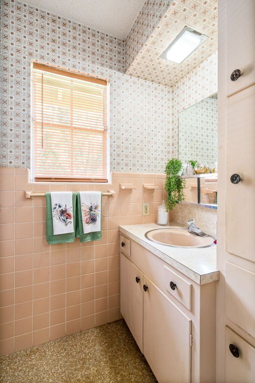 3503 Carla Dr, Austin, TX 78754 - bathroom with vanity, wallpapered walls, a wainscoted wall, and tile walls