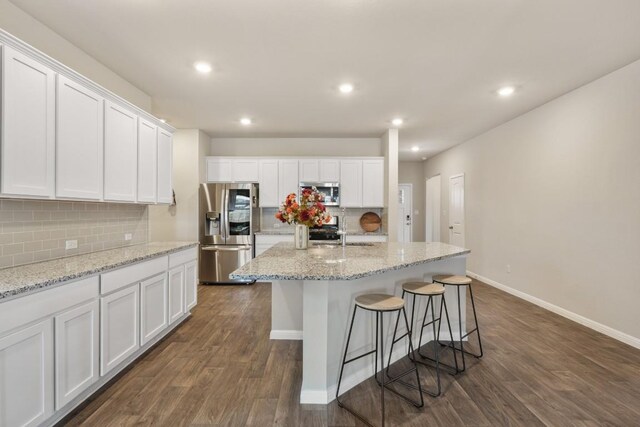 408 Rainmaker Ln, Bastrop, TX 78602 - kitchen featuring stainless steel appliances, dark wood finished floors, white cabinets, decorative backsplash, and recessed lighting