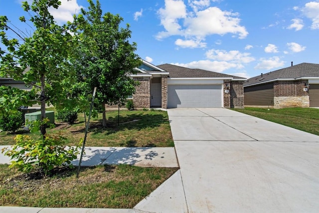 241 Madrid, Kyle, TX 78640 - view of front of home with brick siding, an attached garage, concrete driveway, and a front lawn
