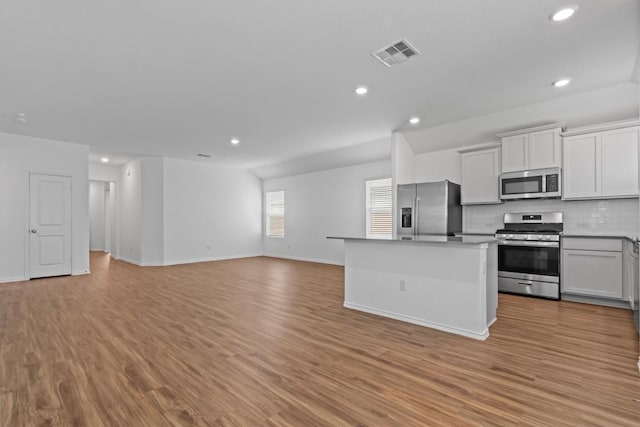 241 Madrid, Kyle, TX 78640 - kitchen with appliances with stainless steel finishes, recessed lighting, open floor plan, tasteful backsplash, and a kitchen island