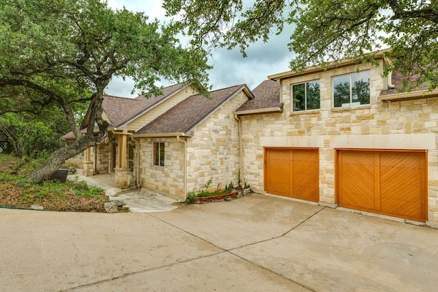 1608 Susan Dr, Austin, TX 78734 - view of front of property with stone siding, roof with shingles, concrete driveway, and a garage