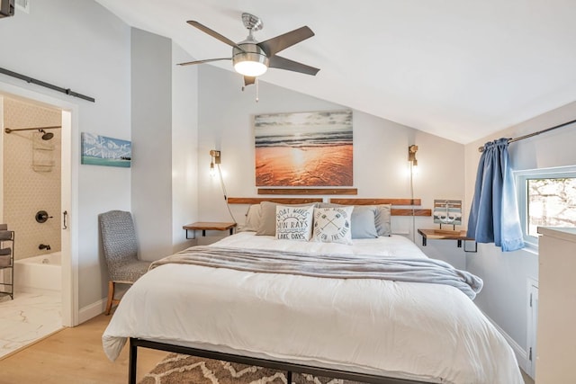 551 Demarett Dr Unit 4, Point Venture, TX 78645 - bedroom featuring lofted ceiling, wood finished floors, connected bathroom, a ceiling fan, and a barn door