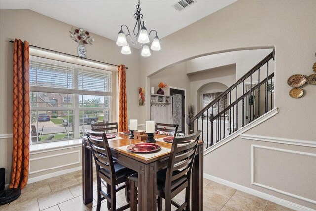 5627 Sabbia Dr, Round Rock, TX 78665 - dining area featuring arched walkways, a chandelier, vaulted ceiling, light tile patterned flooring, and stairway
