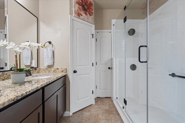 5627 Sabbia Dr, Round Rock, TX 78665 - bathroom with a shower stall, vanity, and stone finish floors