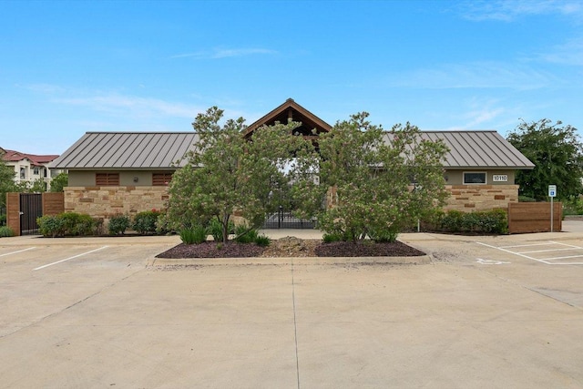 10204 Tildon Ave, Austin, TX 78754 - view of front of property featuring a standing seam roof, stone siding, and a metal roof