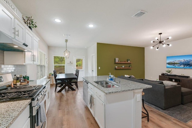 10204 Tildon Ave, Austin, TX 78754 - kitchen with stainless steel appliances, light wood-style floors, open floor plan, white cabinets, and a chandelier