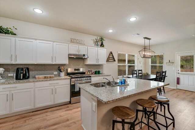 10204 Tildon Ave, Austin, TX 78754 - kitchen featuring stainless steel gas range oven, under cabinet range hood, light wood-style floors, white cabinets, and recessed lighting