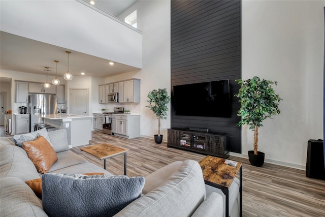 13901 Zuhause Dr, Pflugerville, TX 78660 - living room with light wood-type flooring, baseboards, and a high ceiling