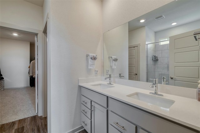 13901 Zuhause Dr, Pflugerville, TX 78660 - bathroom featuring double vanity, tiled shower, ensuite bathroom, baseboards, and recessed lighting