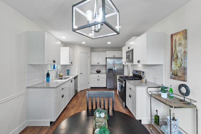 10802 Thicket Trl, Austin, TX 78750 - kitchen featuring stainless steel appliances, a sink, dark wood-type flooring, decorative backsplash, and white cabinets