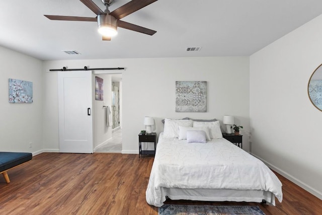 10802 Thicket Trl, Austin, TX 78750 - bedroom featuring wood finished floors, a barn door, baseboards, and ceiling fan