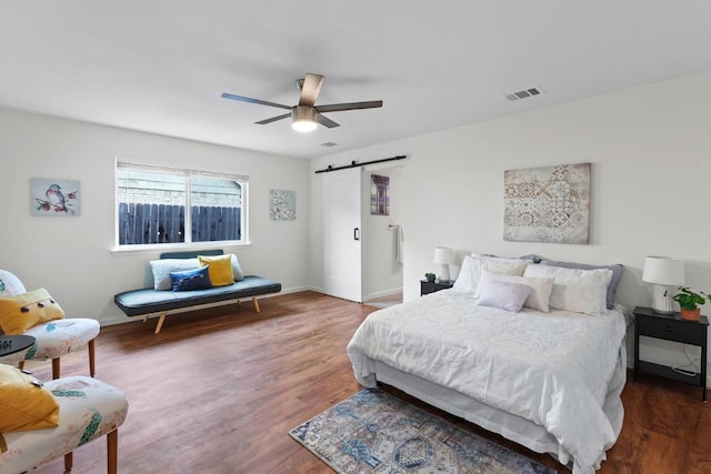 10802 Thicket Trl, Austin, TX 78750 - bedroom featuring a barn door, wood finished floors, a ceiling fan, and baseboards