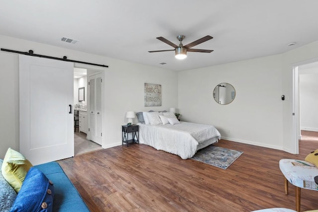 10802 Thicket Trl, Austin, TX 78750 - bedroom featuring a barn door, wood finished floors, baseboards, and a ceiling fan