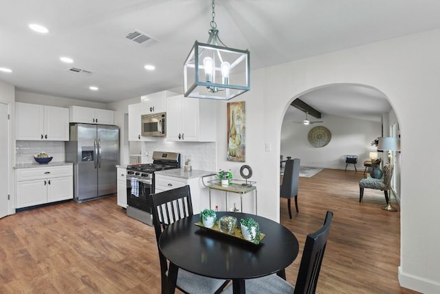 10802 Thicket Trl, Austin, TX 78750 - dining space featuring arched walkways, wood finished floors, recessed lighting, ceiling fan, and lofted ceiling
