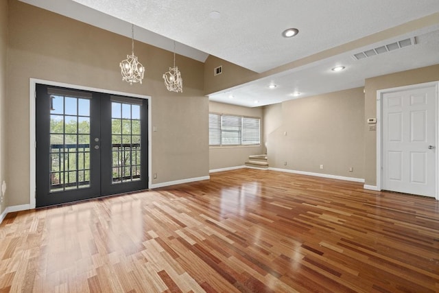 8888 Tallwood Dr Unit 1301, Austin, TX 78759 - unfurnished room featuring a chandelier, wood finished floors, baseboards, french doors, and lofted ceiling