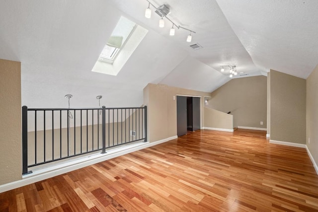 8888 Tallwood Dr Unit 1301, Austin, TX 78759 - bonus room with a skylight, wood finished floors, vaulted ceiling, and a textured ceiling