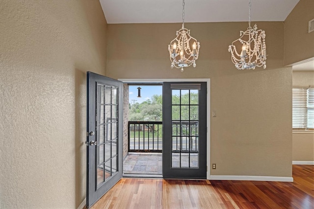 8888 Tallwood Dr Unit 1301, Austin, TX 78759 - doorway with a chandelier, a textured wall, wood finished floors, and french doors