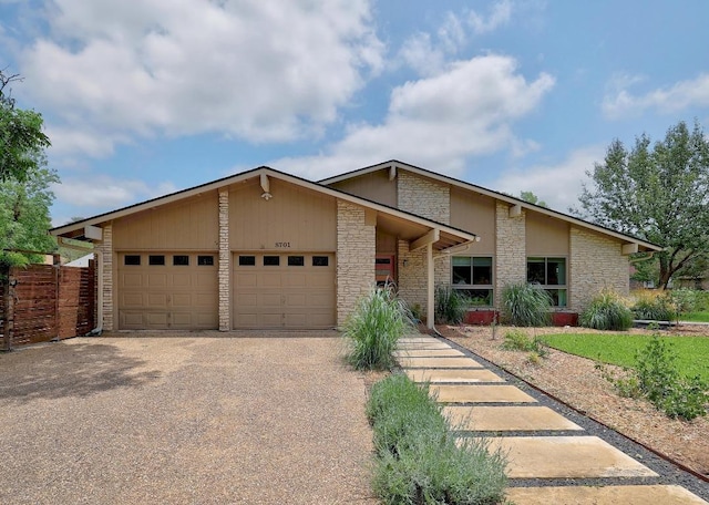8701 Millway Dr, Austin, TX 78757 - mid-century home with stone siding, a garage, and driveway