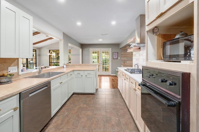 8701 Millway Dr, Austin, TX 78757 - kitchen featuring black appliances, a sink, tasteful backsplash, island range hood, and light countertops