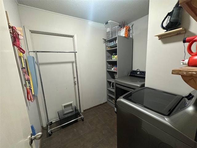 8701 Millway Dr, Austin, TX 78757 - laundry area with washing machine and dryer, a textured ceiling, and dark tile patterned floors