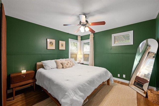 109 W 55th 1/2 St, Austin, TX 78751 - bedroom with wood finished floors, wainscoting, a ceiling fan, and a decorative wall