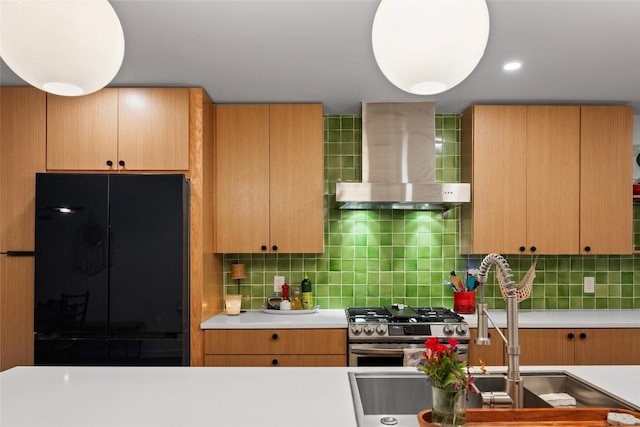 109 W 55th 1/2 St, Austin, TX 78751 - kitchen featuring wall chimney exhaust hood, black fridge, a sink, stainless steel range with gas stovetop, and tasteful backsplash