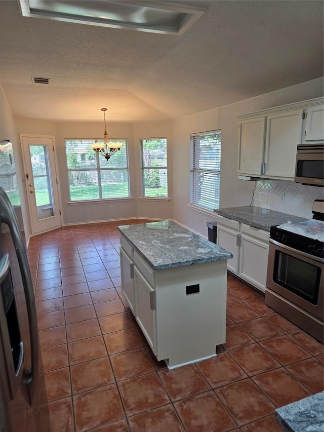 3401 Kissman Dr, Austin, TX 78728 - kitchen with appliances with stainless steel finishes, healthy amount of natural light, dark tile patterned floors, and backsplash