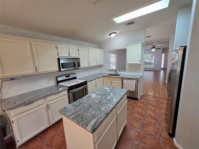 3401 Kissman Dr, Austin, TX 78728 - kitchen with stainless steel appliances, a sink, lofted ceiling, a skylight, and tasteful backsplash
