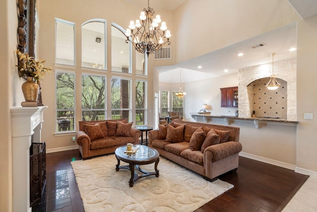 15 Sarazen Loop N, Georgetown, TX 78628 - living area with dark wood-style flooring, a chandelier, a high ceiling, and a fireplace