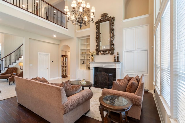 15 Sarazen Loop N, Georgetown, TX 78628 - living room featuring a towering ceiling, healthy amount of natural light, built in features, dark wood-type flooring, and a tile fireplace