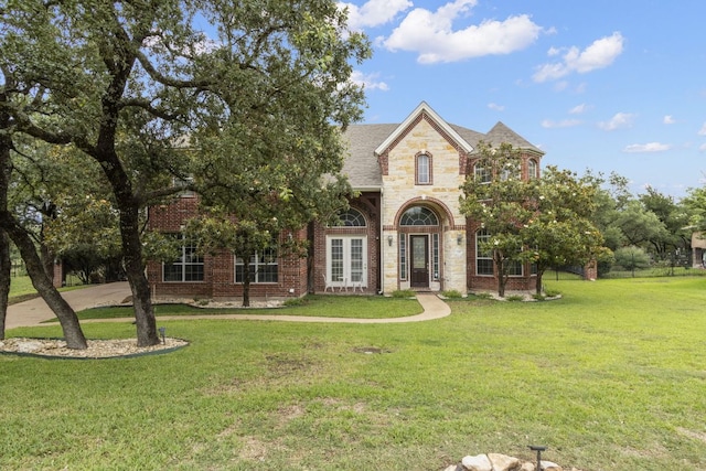 15 Sarazen Loop N, Georgetown, TX 78628 - view of front of home with a front lawn, brick siding, and roof with shingles