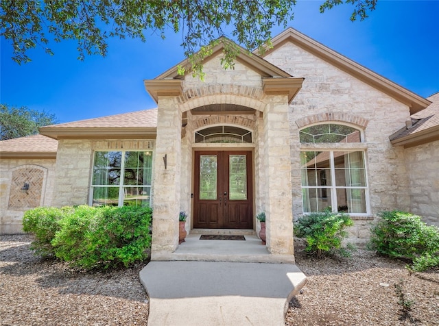 104 E Rustle Cv, Georgetown, TX 78628 - doorway to property with stone siding and a shingled roof