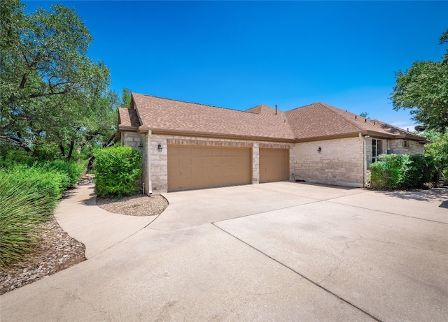 104 E Rustle Cv, Georgetown, TX 78628 - view of side of property featuring stone siding, a garage, driveway, and roof with shingles
