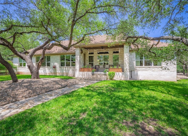 104 E Rustle Cv, Georgetown, TX 78628 - rear view of house featuring a yard, stone siding, and a porch