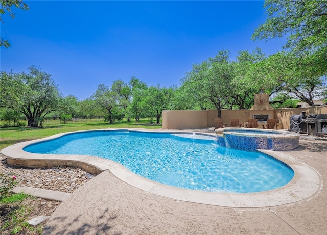 104 E Rustle Cv, Georgetown, TX 78628 - view of swimming pool with a patio area, a pool with connected hot tub, a grill, and view of wooded area