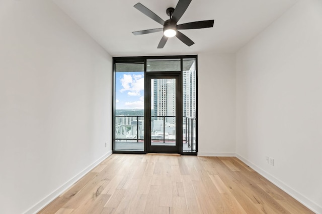 84 E Ave Unit 2108, Austin, TX 78701 - spare room with floor to ceiling windows, light wood-style flooring, a ceiling fan, and baseboards
