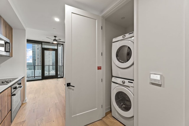 84 E Ave Unit 2108, Austin, TX 78701 - laundry area featuring stacked washer and clothes dryer, a ceiling fan, and light wood-style floors