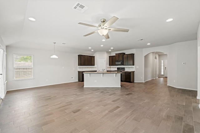1012 Chad Loop, Round Rock, TX 78665 - unfurnished living room featuring ceiling fan, arched walkways, wood finished floors, recessed lighting, and lofted ceiling