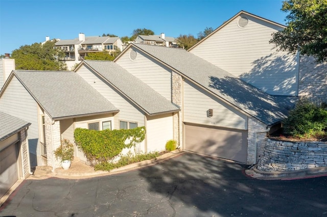 1520 Ben Crenshaw Way Unit 120, Austin, TX 78746 - view of front of house with driveway, an attached garage, and a shingled roof