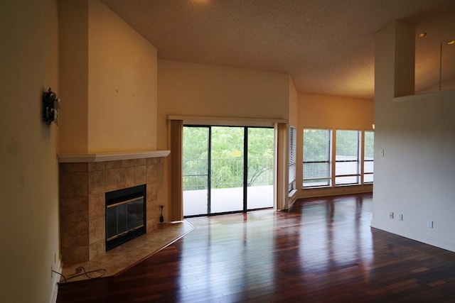 1520 Ben Crenshaw Way Unit 120, Austin, TX 78746 - unfurnished living room with a fireplace, wood finished floors, a textured ceiling, and baseboards