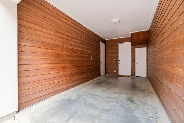 3100 Menchaca Rd Unit 33, Austin, TX 78704 - hallway featuring concrete flooring and wood walls