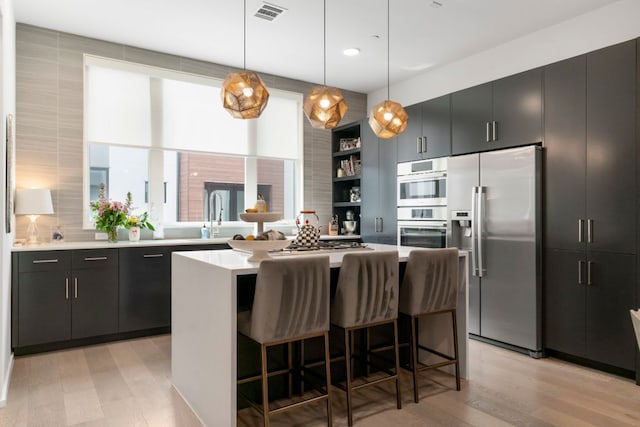 3100 Menchaca Rd Unit 33, Austin, TX 78704 - kitchen with stainless steel appliances, a sink, light countertops, a center island, and open shelves